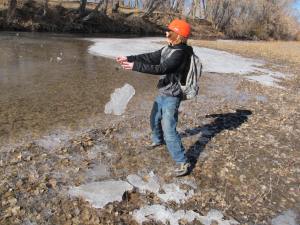 Throwing hunks of ice onto the icy area that looks like just plain water