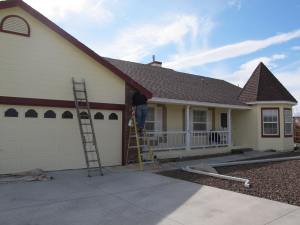 Painting the trim on the front of the house.
