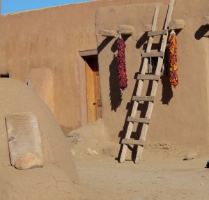 The red and multicolored things hanging down are called ristras. The red one is made up on red chiles while the other one is basically ornamental with multi-colored corn ears. The pueblo people used the corn mostly while the chiles were grown in the southern part of the state.