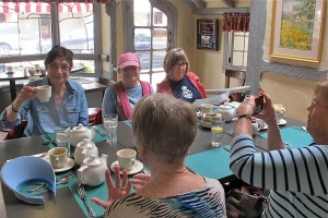 Thanks, Sherry, for the salute with the teacup. I note in this picture that Trish is talking with her hands again. She’s good at that and doesn’t knock things on the floor as I would with the hand motions. 